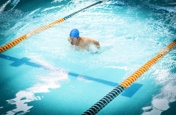 Young athletic man with butterfly swimming technique.