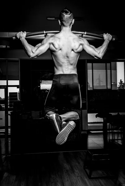 Joven musculoso en gimnasio — Foto de Stock