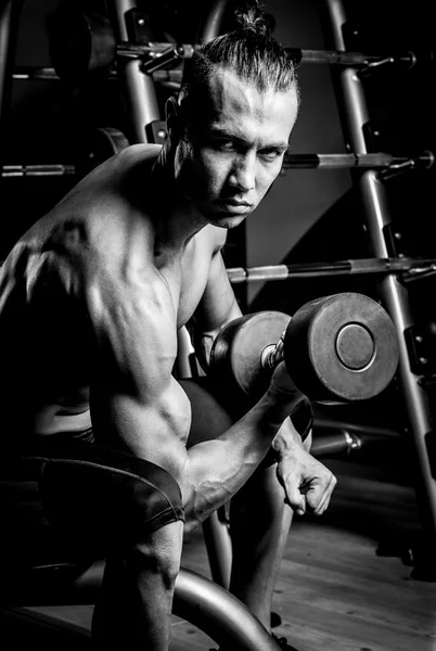 Joven musculoso en gimnasio — Foto de Stock