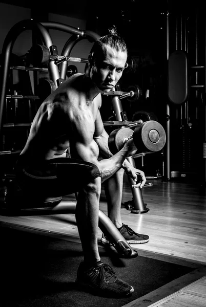 Joven musculoso en gimnasio — Foto de Stock