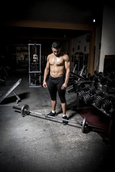 Junger Mann trainiert in dunklem und altem Fitnessstudio — Stockfoto