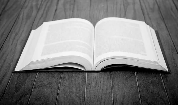 Красочные книги на деревянном столе черно-белые — стоковое фото