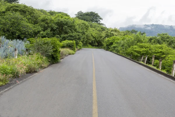 Estrada cercada por montanhas e natureza — Fotografia de Stock