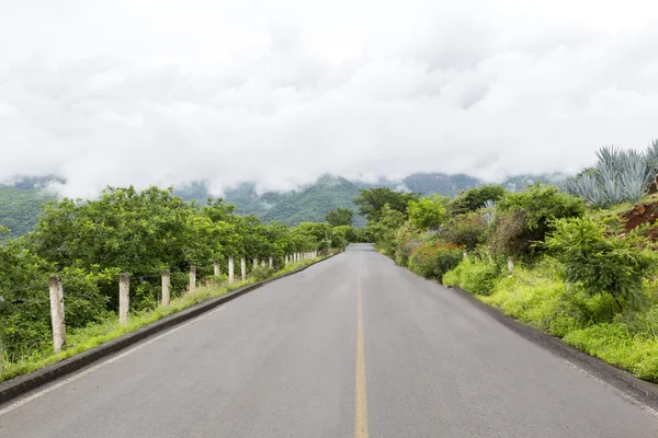 Estrada cercada por montanhas e natureza — Fotografia de Stock