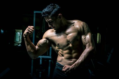 Genç adam karanlık ve yaşlı spor salonunda egzersiz yapıyor.