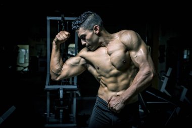 Genç adam karanlık ve yaşlı spor salonunda egzersiz yapıyor.
