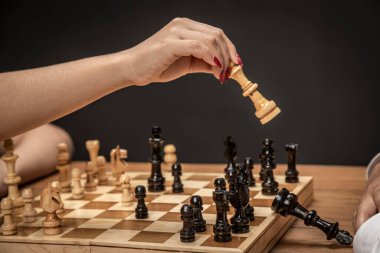 Satranç tahtasında oynayan kadının eli kazanan hamleyi yapıyor..