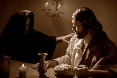 Jesus looking at Judas Christ with maiicious look during the last supper clipart