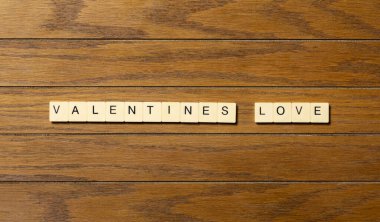 Arkaplan konsepti Sevgililer Günü sözlerinin tahta masadaki bloklara yazılmasını sever