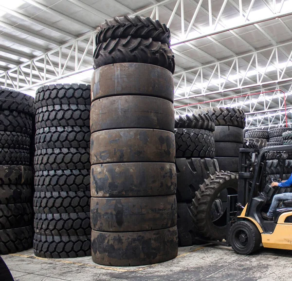 Warehouse full of new and used tires stacked one on top of the other.