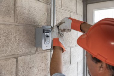 Erkek elektrikçinin portresi bir fabrikada elektrik tesisatı yaparken performans sergiliyor..