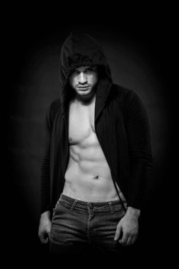 Esrarengiz, güçlü ve siyah tişörtlü bir adam. Siyah ve beyaz.