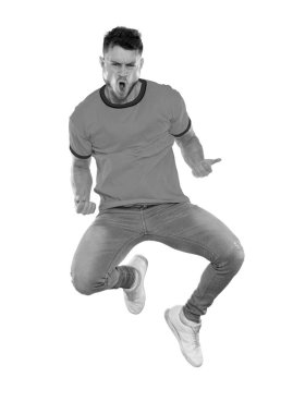 Sarı ve yeşil tişörtlü genç kaslı adam takımının zaferini kutluyor. Siyah ve beyaz.