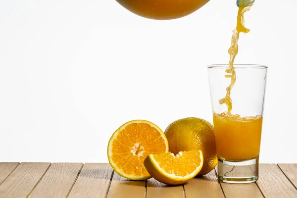 Spruta Apelsinjuice Faller Transparent Glas Kopp Träbord Wnite Bakgrund — Stockfoto