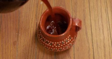 Kahve fıskiyesi ahşap masada kil sürahide servis ediliyor..