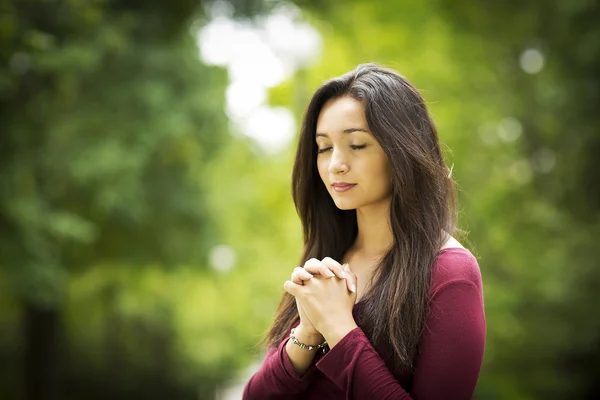 Женщина молится на открытом воздухе — стоковое фото