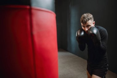 Bir boksör kum torbasını yener. Boksör ringde yumruk pratiği yapıyor. Sporcu kum torbasıyla saldırır. 4k video