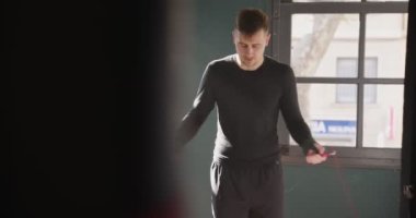 Spor salonunda ip atlayan bir erkek sporcu. Boxer ip atlama. Gölge boksu. Sportsem spor salonunda antrenman yapıyor. 4k video