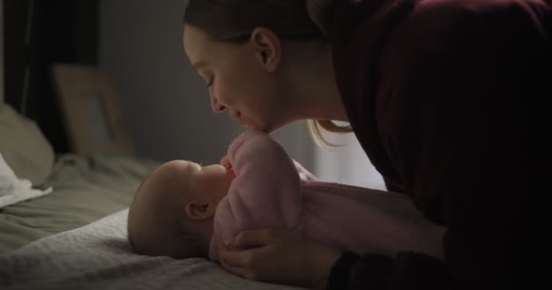 Fiatal, gyönyörű anya kisbabával. Újszülött az anyjával. Az anya mosolyog a babájára. Boldog fiatal nő a babájával. 4k videó — Stock videók