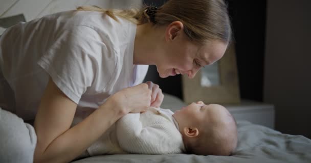 Jovem mãe bonita com bebê. Um bebé recém-nascido com a mãe. A mãe sorri para o bebé. Jovem feliz com o seu bebé. 4k vídeo — Vídeo de Stock