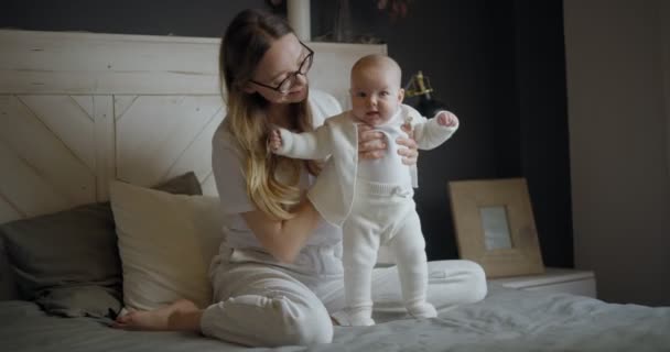 Boldog nő ránéz a babájára és mosolyog. Gyönyörű baba mosolyog anyára. Anya a saját gyerekével.. — Stock videók