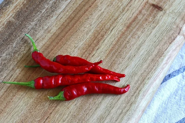 Chilli vermelho fresco na placa de corte de madeira . — Fotografia de Stock