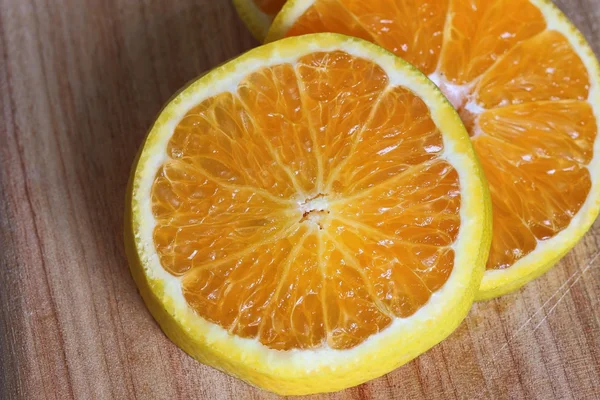 Naranja en rodajas en tablero de corte de madera — Foto de Stock