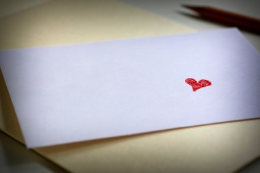 Beyaz zarf üzerinde kırmızı aşk kalp