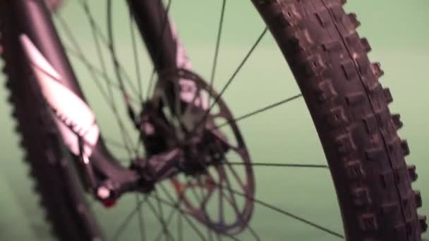 Rotazione e arresto ruota mountain bike su sfondo verde . — Video Stock