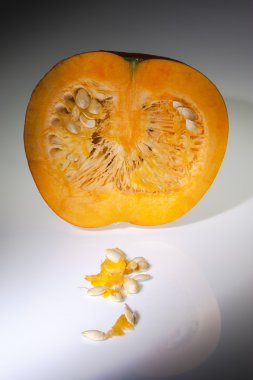 Beyaz arka planda tohumları ile yarım portakal kabak