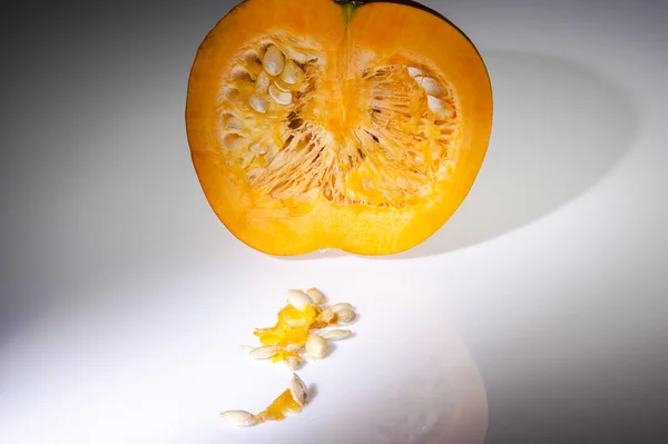 Beyaz arka planda tohumları ile yarım portakal kabak — Stok fotoğraf