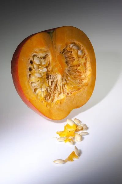 一个半橙色的南瓜，种子在白色背景 — 图库照片