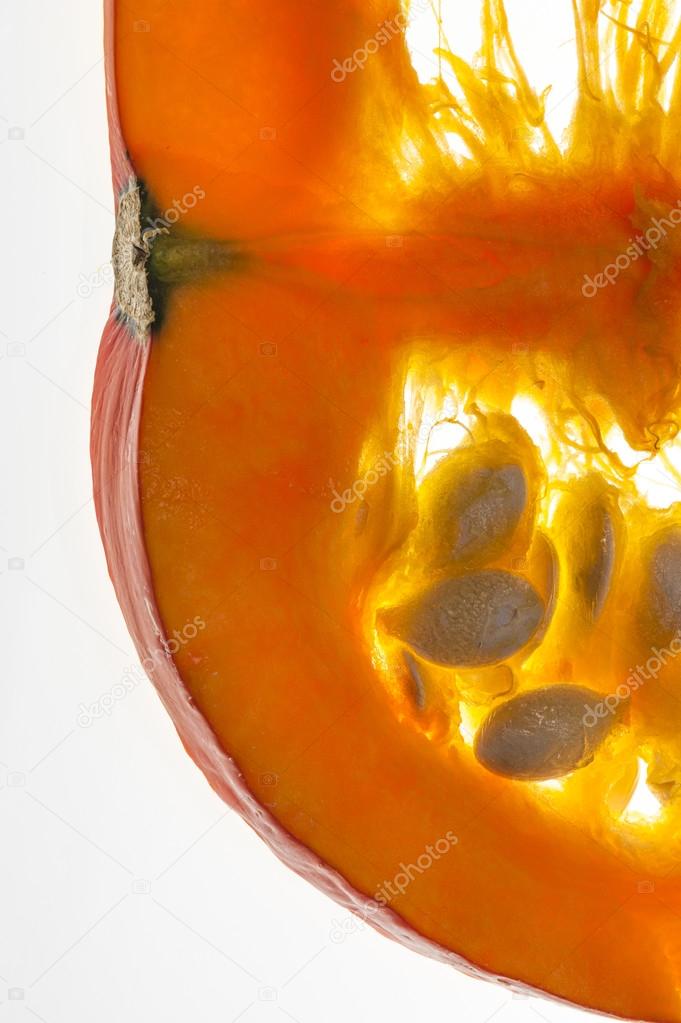 Closeup of slice of orange pumpkin without pulp. White background.