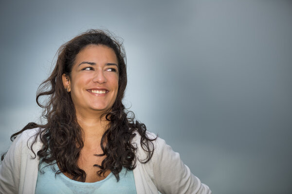 Young woman smiling with dark cloudscape background (copy space)