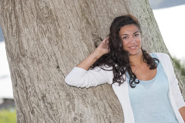 Mulher jovem bonito posando na frente de tronco de árvore grande — Fotografia de Stock