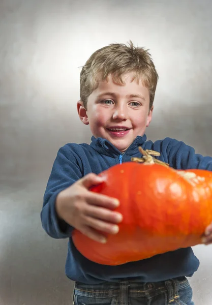 Little boy holding an heavy pumpkin. Halloween theme — Stock Photo, Image