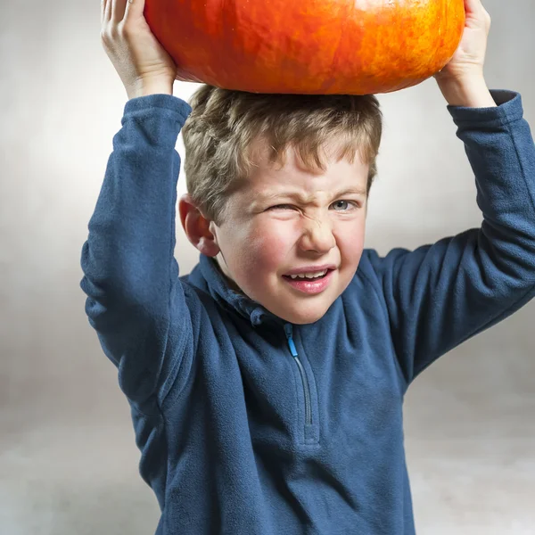 Little boy making a face with heavy pumpkin hat — Stock Photo, Image