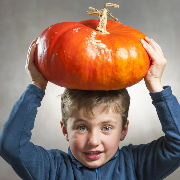 Facial portrait of  little boy with pumpkin on his head — Stock Photo, Image