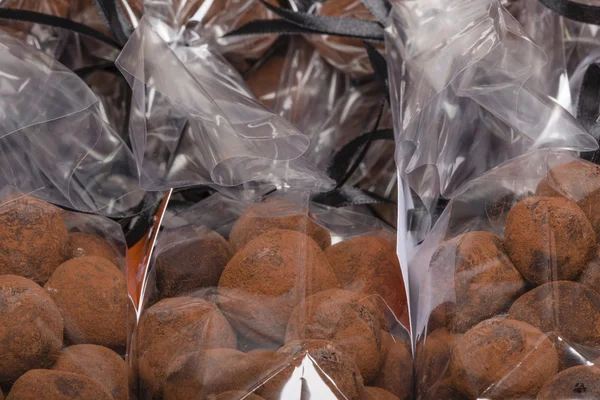 Gros plan sur les truffes au chocolat dans des sacs en plastique empilés — Photo