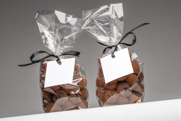 Чистые подарочные бирки с лентой на двух пакетах шоколадных трюфелей — стоковое фото