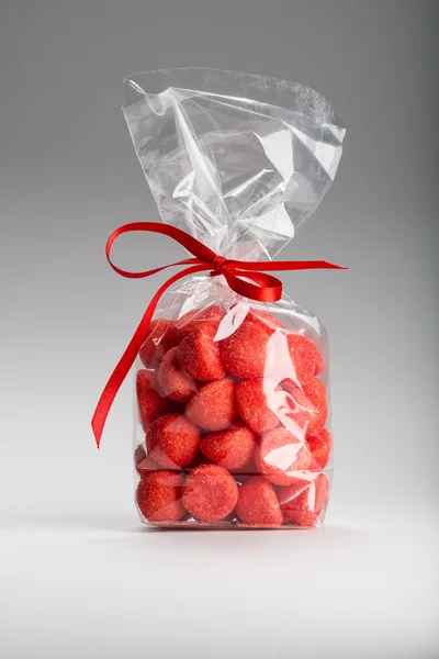 Plastic bag of acidulous strawberries isolated with elegant red — Stock Photo, Image