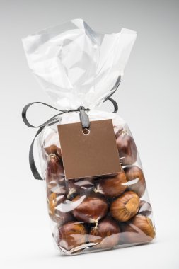 Gift with ribbon of fresh chestnuts with brown blank  label