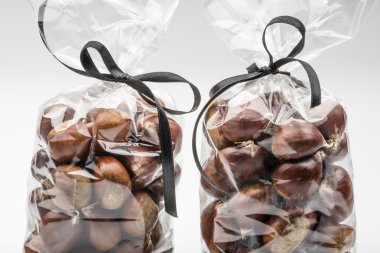 Closeup on chestnuts in couple of luxury bags with  ribbons.
