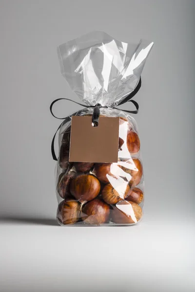 Luxury gift with ribbon of chestnuts with brown blank label — Stock Photo, Image