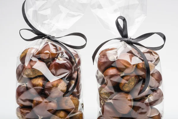Closeup on sweet chestnuts in luxury bags with elegant ribbons.