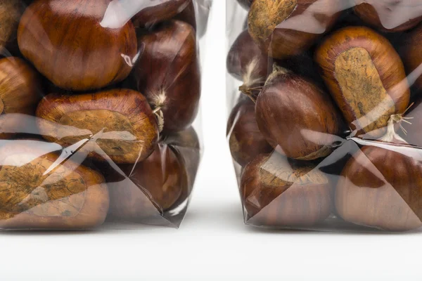 Closeup on fresh chestnuts in two luxury plastic bag — Stock fotografie