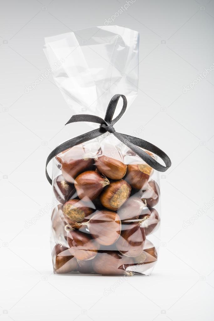 Luxury bag of sweet chestnuts isolated with elegant black ribbon