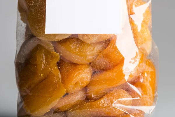 Macro of candied apricots in luxury transparent plastic bag — Stock Photo, Image