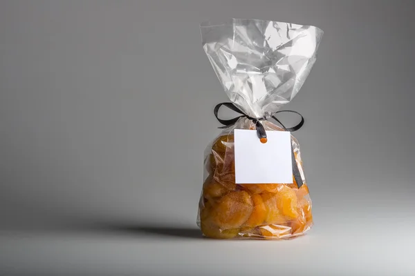Elegant transparent bag of apricots with blank label and copy space — Stock Photo, Image