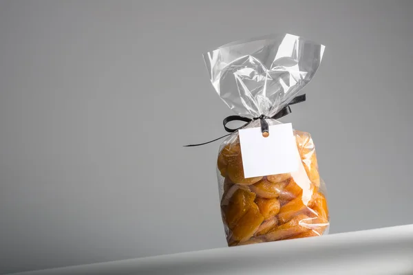 Transparent bag of candied apricots with blank label and copy space — Stock Photo, Image